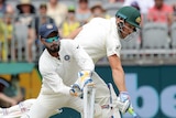 Australian batsman Aaron Finch slides his bat over the crease as Rishabh Pant takes the bails off during a Test match.