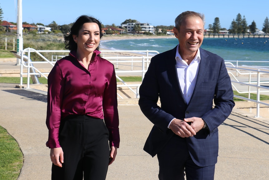 Magenta Marshall and Premier Roger Cook walking on an ocean-front footpath.