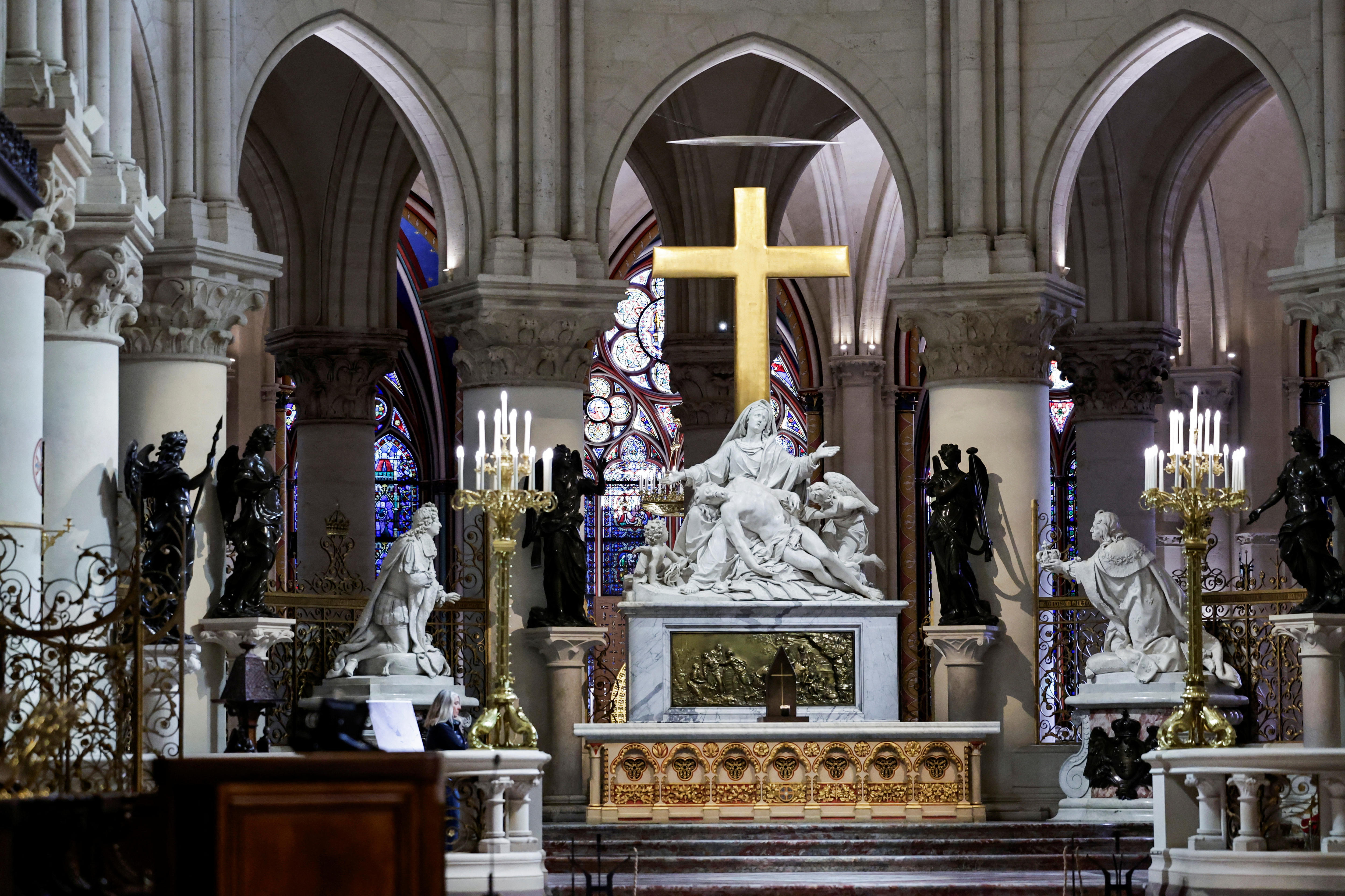 An elaborate church altar with a statue of Mary and Jesus surrounded by other marble and gold figures