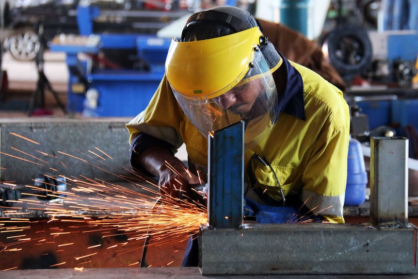 CDP participant Aaron Miller learns to use a grinder at Crowhurst Engineering in Katherine.