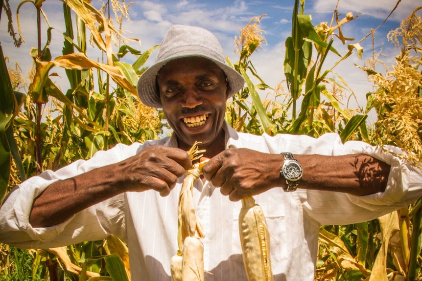 Joel Sindayigaya holds freshly harvested maize.