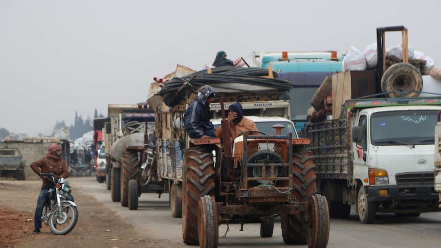 Civilians pile trucks and tractors high with equipment
