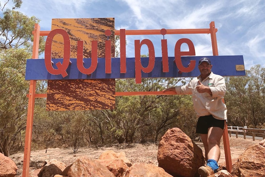 Brendan Farrell stands in front of sign for Quilpie, Queensland