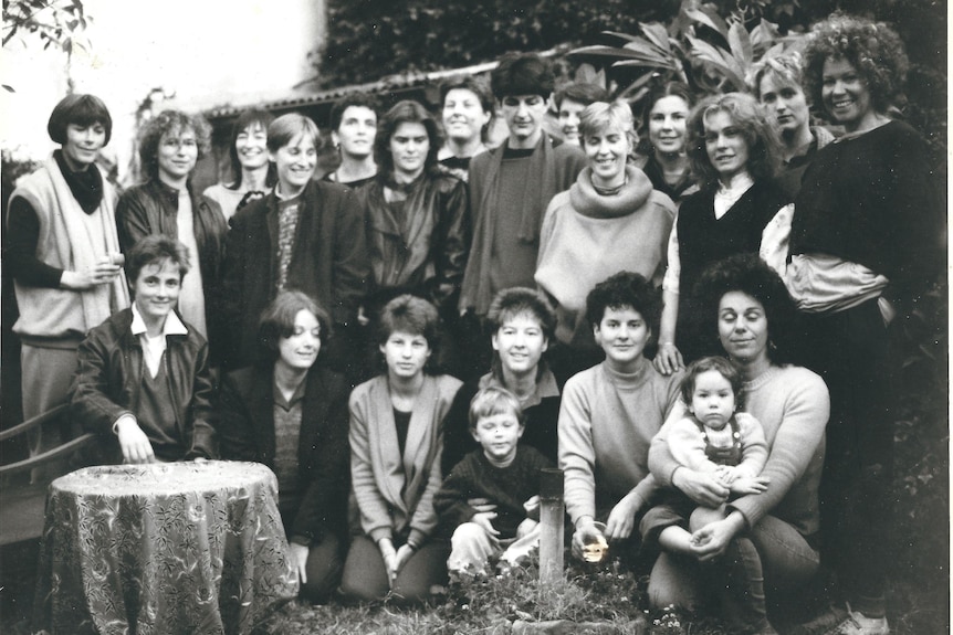 Black and white picture of a large group of women in 1970s smiling at the camera 
