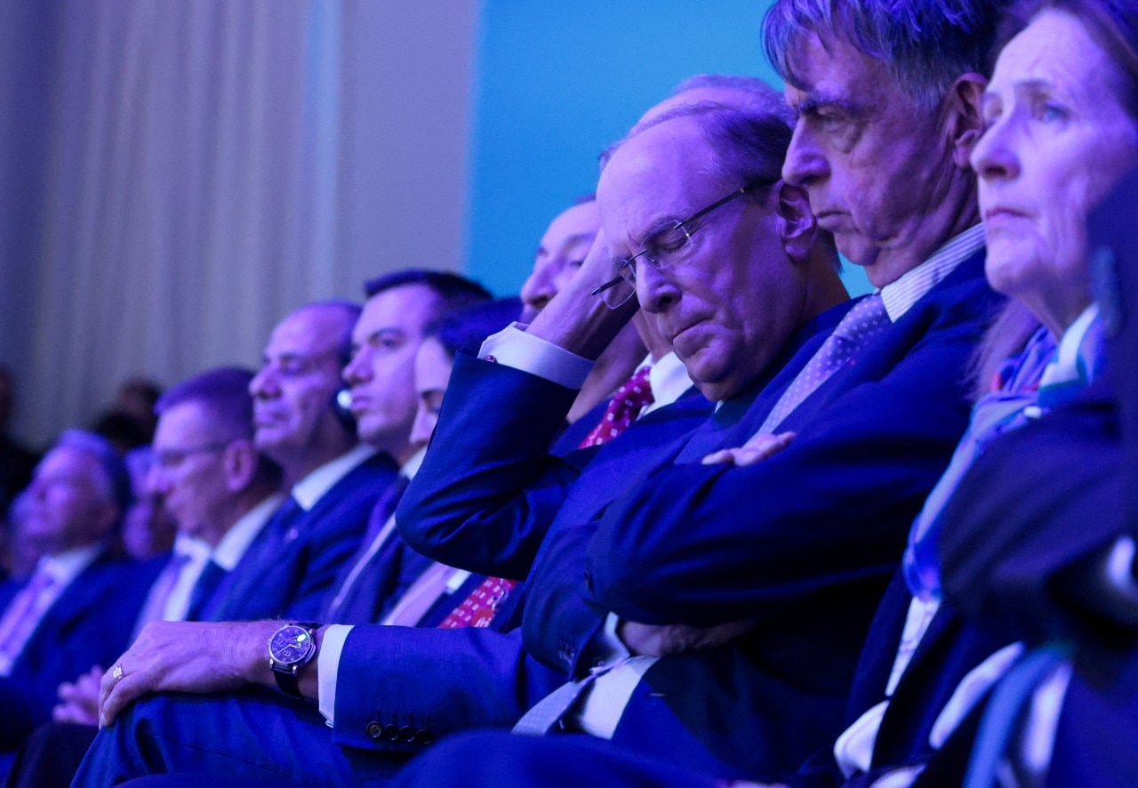 A line of seated people looking serious.