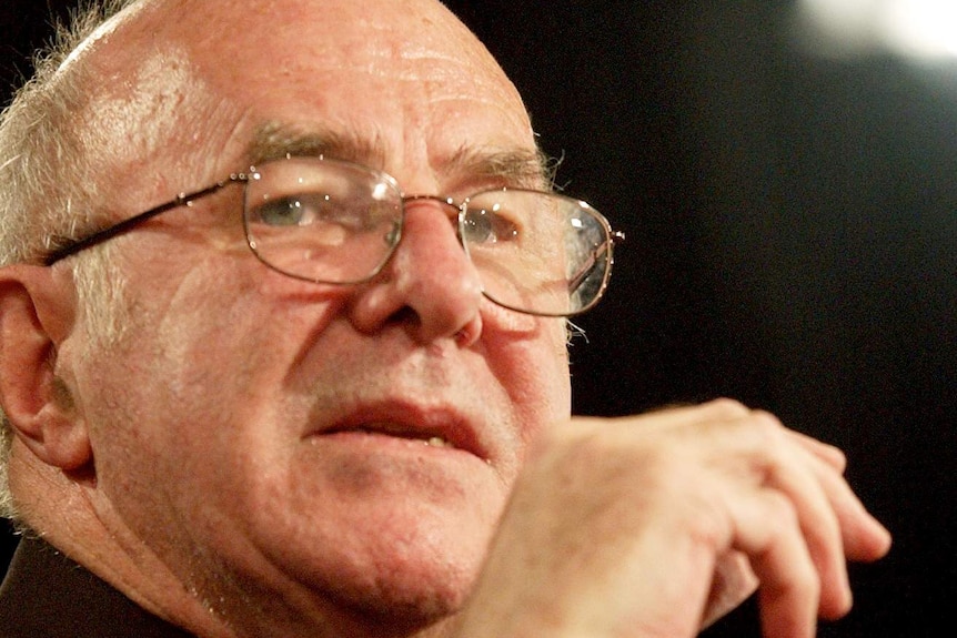 Clive James wearing glasses and a black top.
