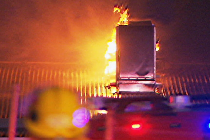 Roof and air conditioner amid fire glow.