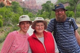 Woman with her two adult children pose for photo.