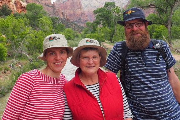 Woman with her two adult children pose for photo.