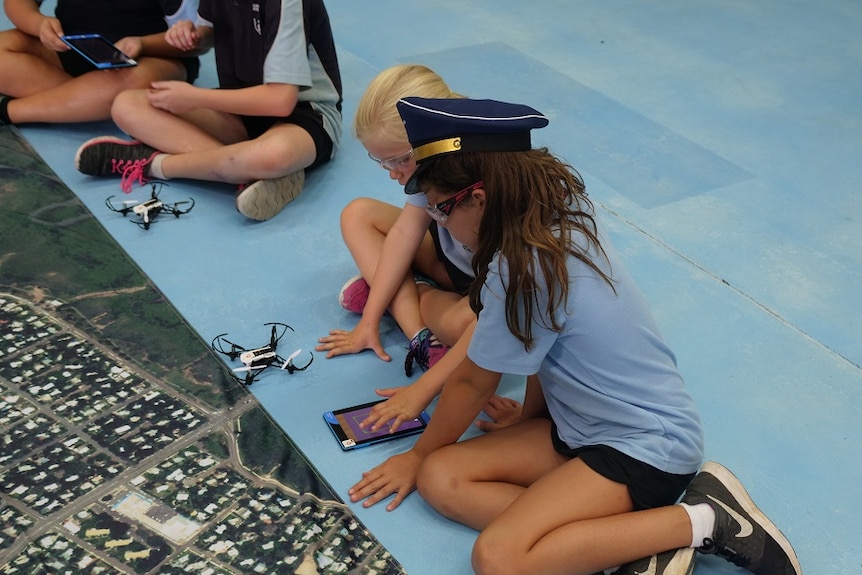 School students touching drone controller