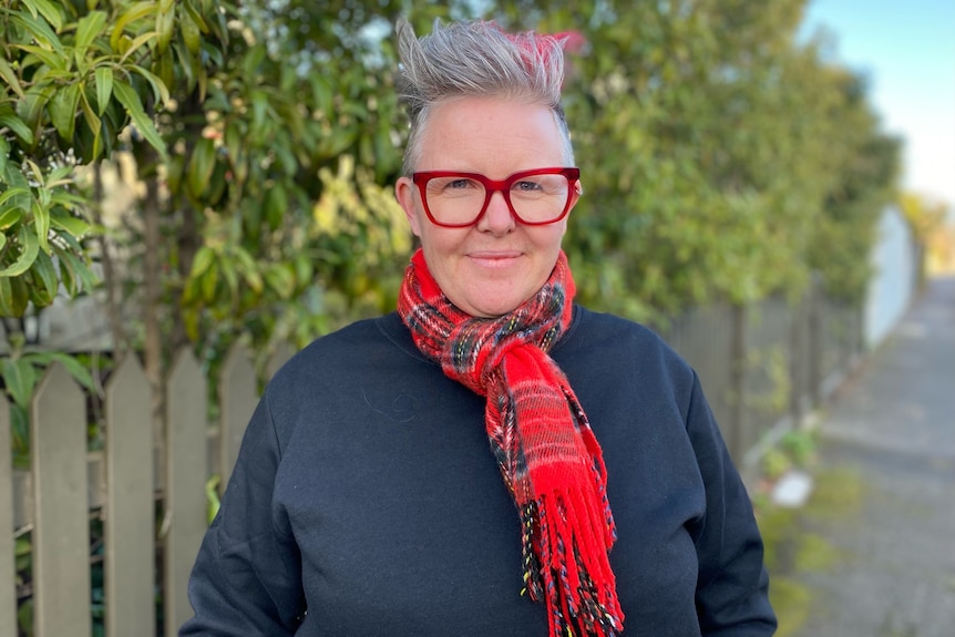 a woman with red glasses and a red scarf.