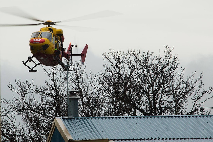 A rescue helicopter hovering above a house in Tasmania.
