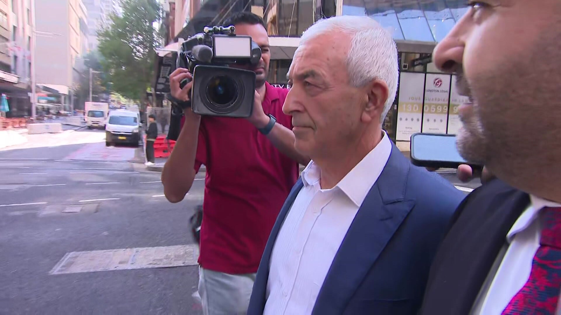 Steve Nassif wearing a blazer and white shirt with a camera on him