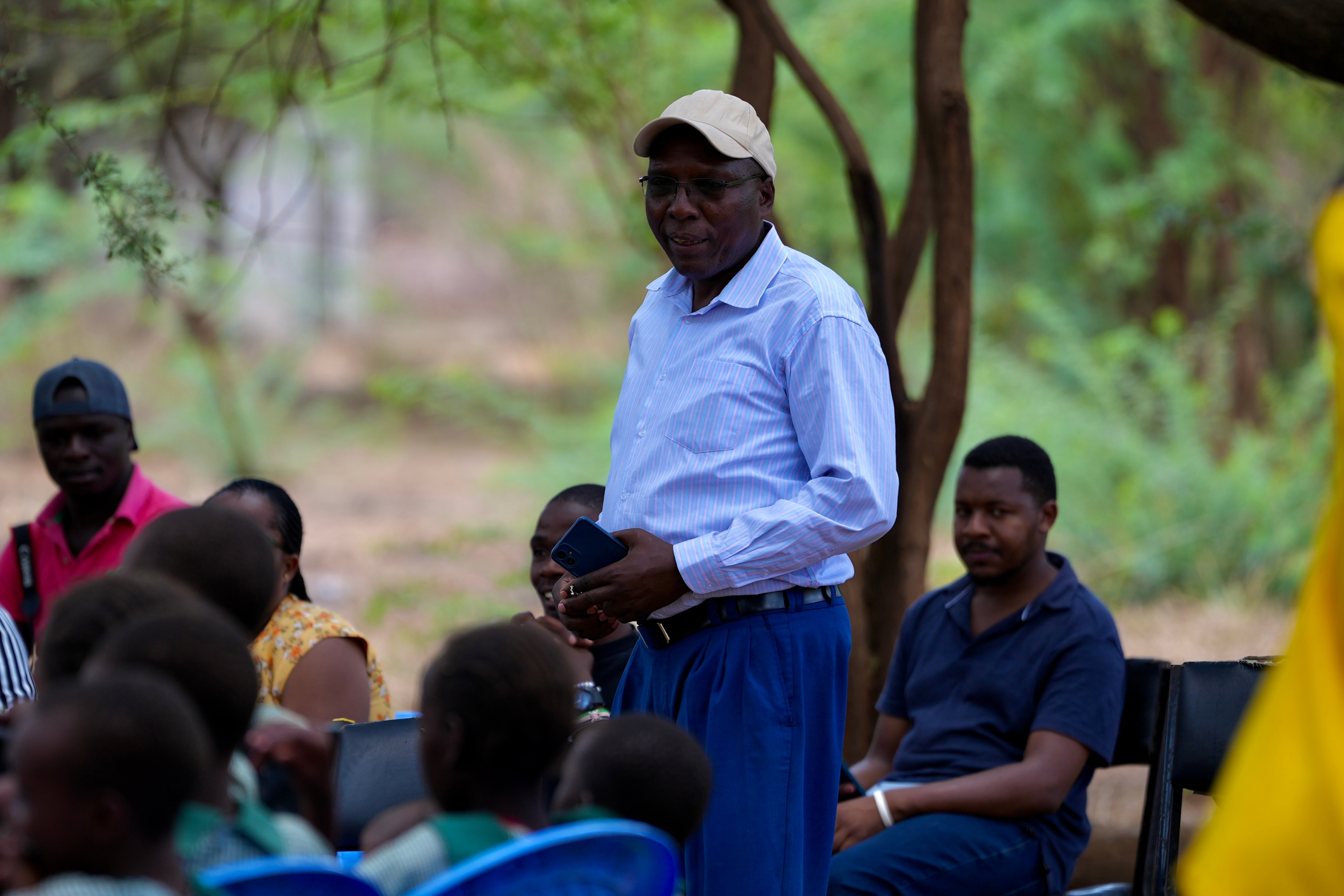 A man addresses a group of students in rural Kenya.