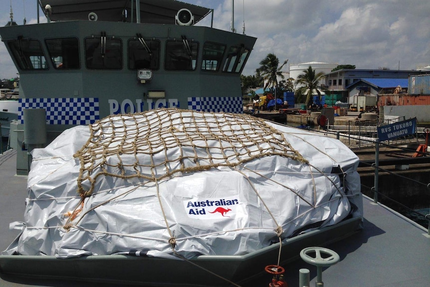 A shipment of aid tied down on the deck of a ship.