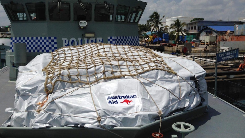 A shipment of aid tied down on the deck of a ship.