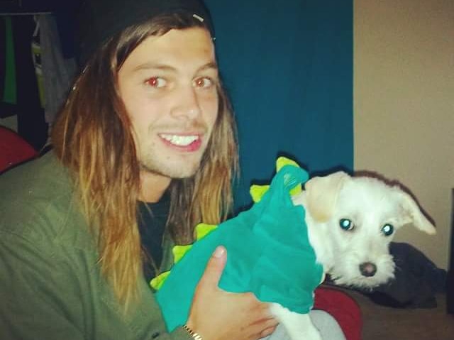 Matthias Bache, who disappeared after diving off a cliff in Western Australia's South West, holds a small white dog.