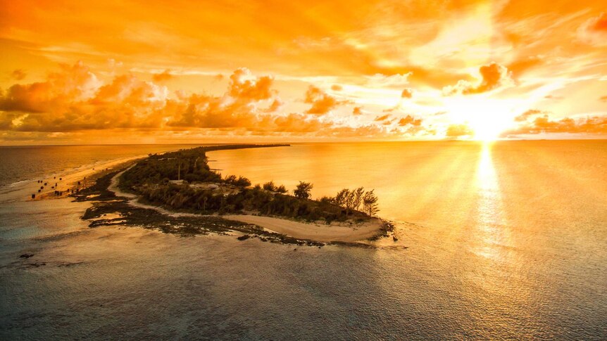 The sun sets in a riot of gold over the Pacific with Enewetak Atoll in the foreground, Marshall Islands, October 2017.