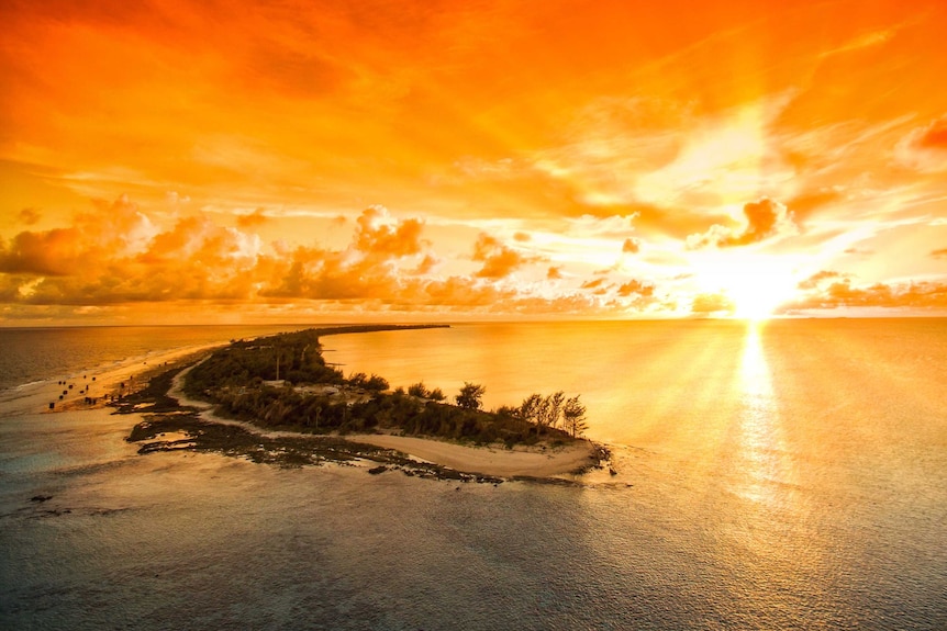The sun sets in a riot of gold over the Pacific with Enewetak Atoll in the foreground, Marshall Islands, October 2017.