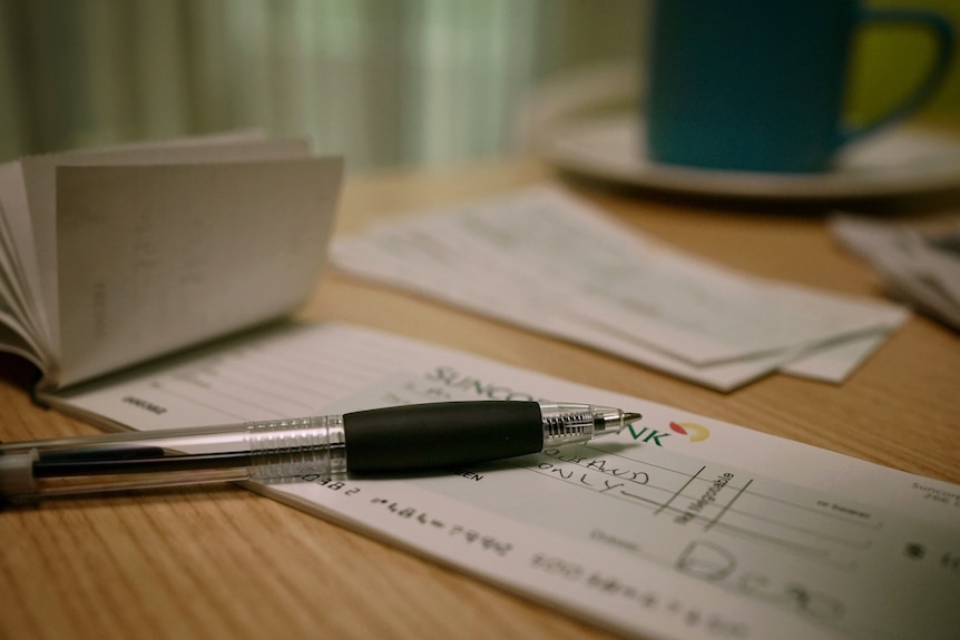a pen resting on a cheque book