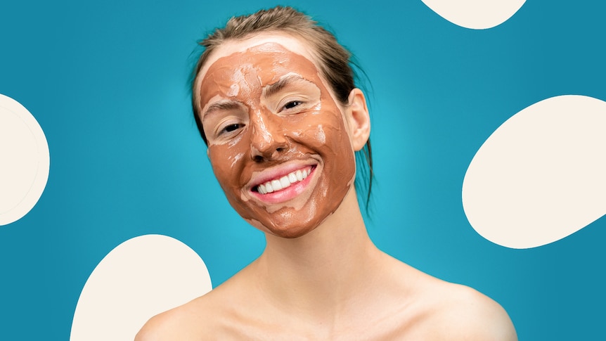 Smiling woman with a clay mask on her face, in a story about debunking the natural, clean skincare trend.