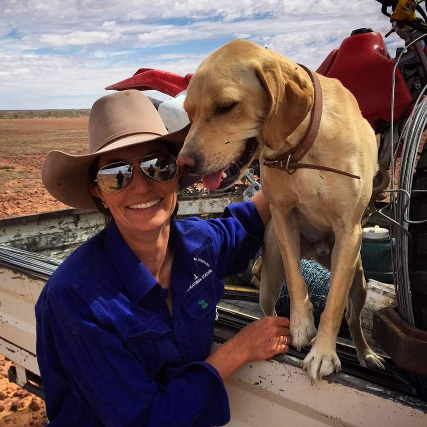 Kelly Theobald with her dog while working as a jillaroo.