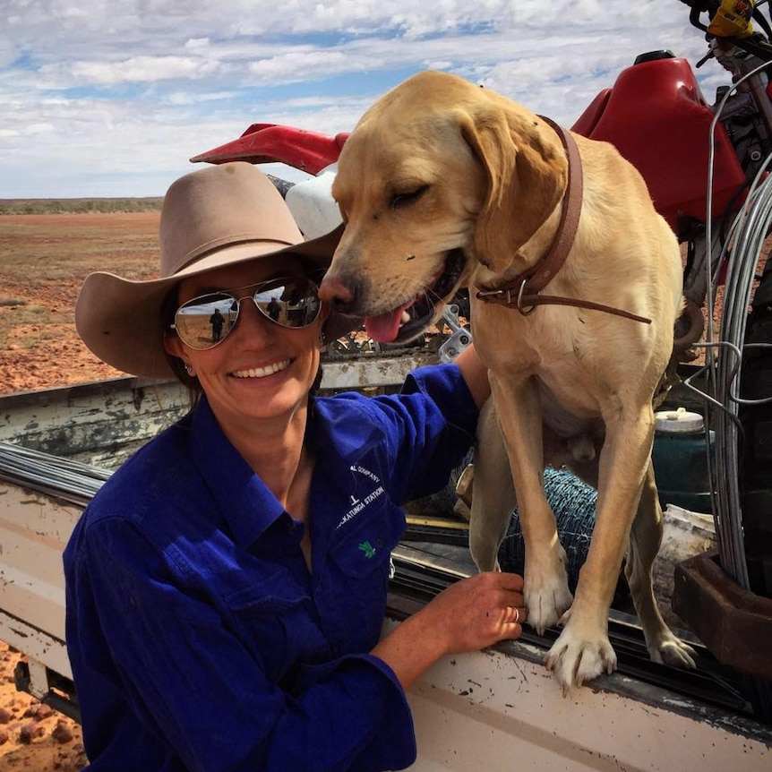 Kelly Theobald with her dog while working as a jillaroo.