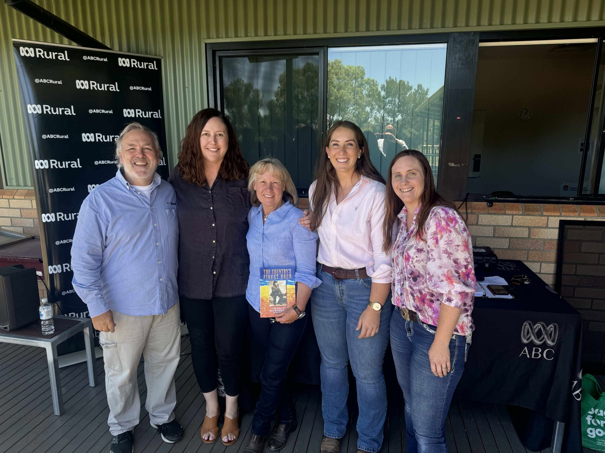 a man on left with four women with outside broadcast equipmwnt behiind