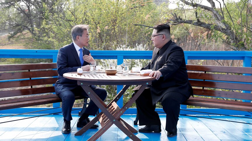 South Korean President Moon Jae-in and North Korean leader Kim Jong Un sit together.