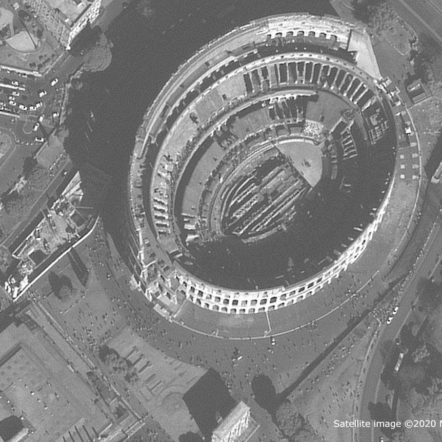 A satellite image of the Coliseum. People are dotted throughout the streets surrounding it.