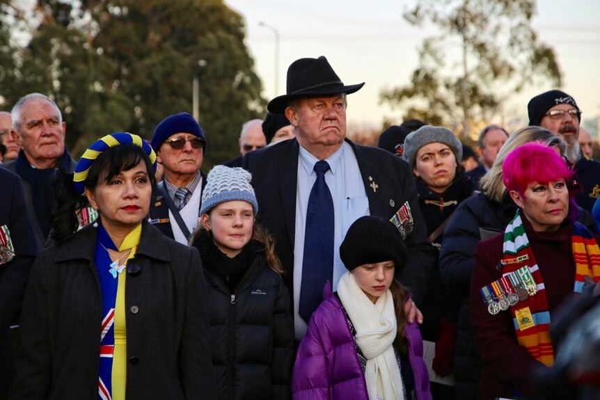 A man wearing medals amongst the crowd.