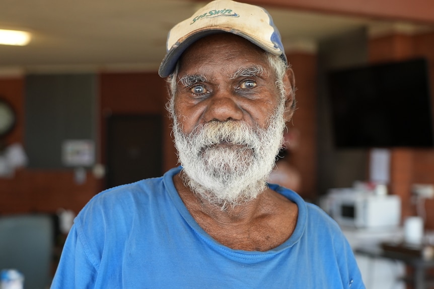 An elderly Aboriginal man in a baseball cap