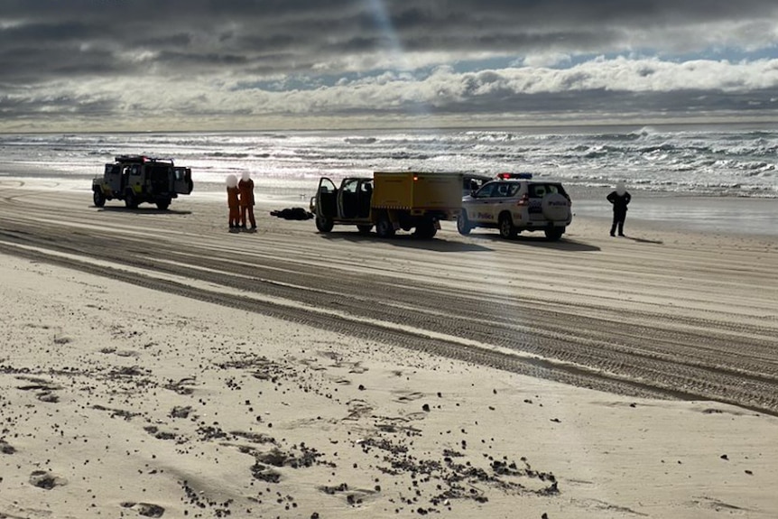 Police and paramedics at the scene of a fatal 4WD vehicle rollover on Fraser Island.