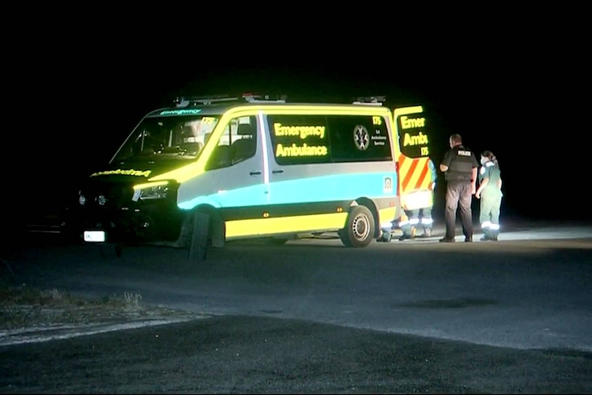 A police officer and paramedic near an ambulance.