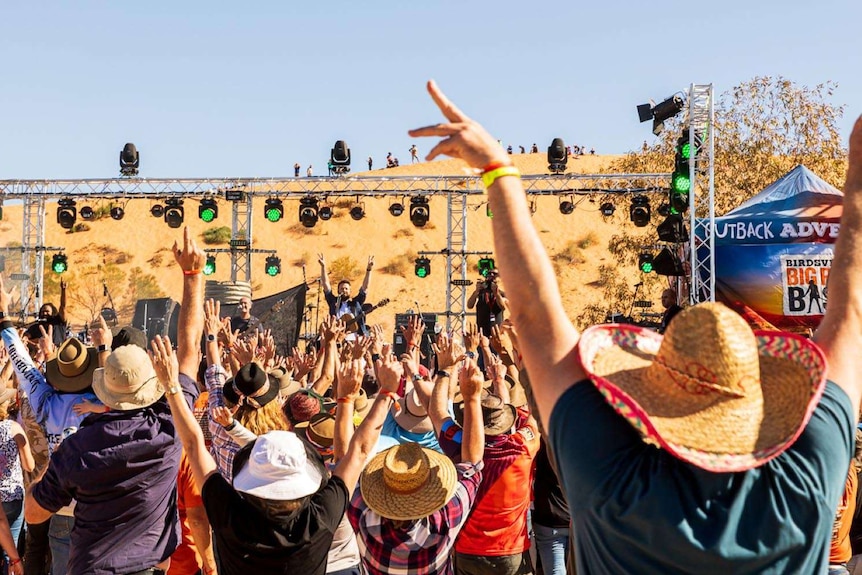 Big Red bash revellers at the Birdsville event, their hands up, dancing to the music