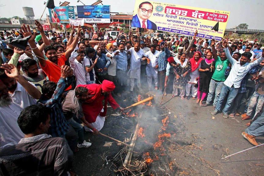 A crowd of people in India burns an effigy depicting PM Narendra Modi in a protest.