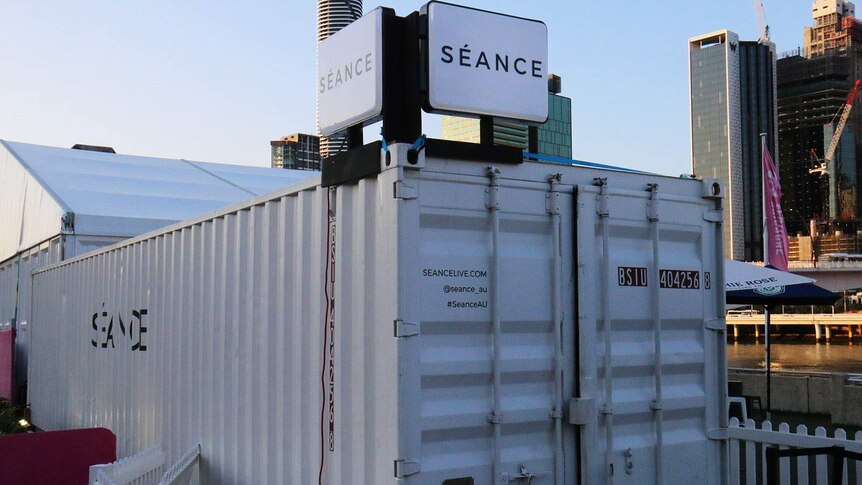 A white shipping container for a theatrical performance called Seance