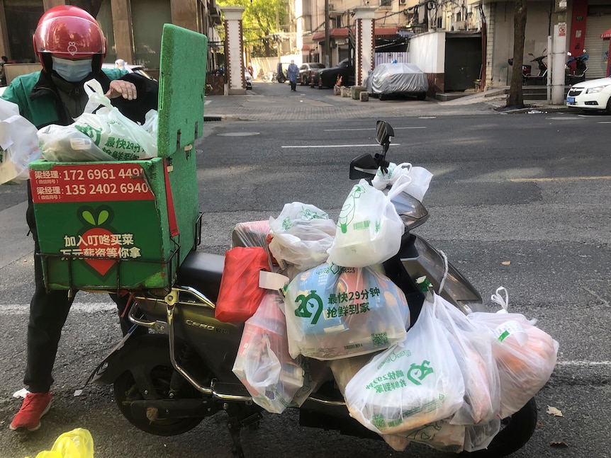 A delivery driver carries lots of packages. 