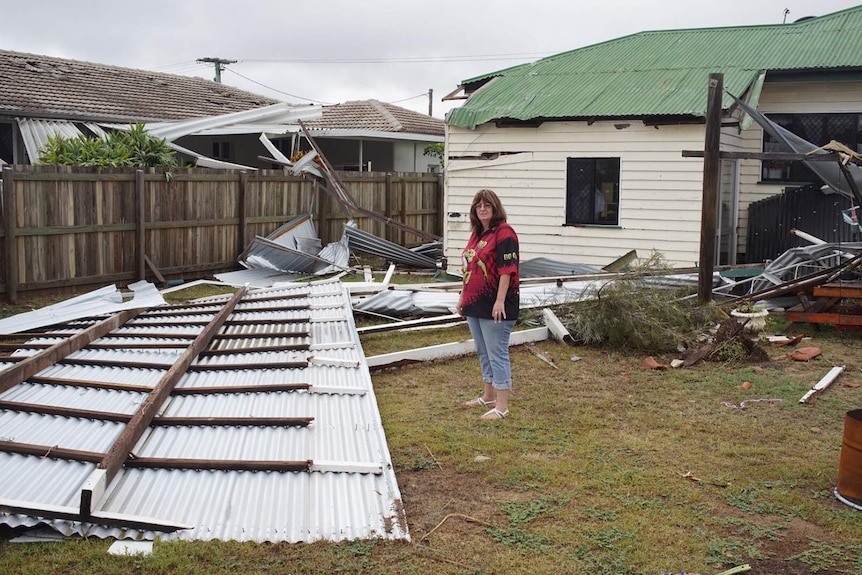 A woman stands in the backyard of a damaged house in Bundaberg on October 3, 2017