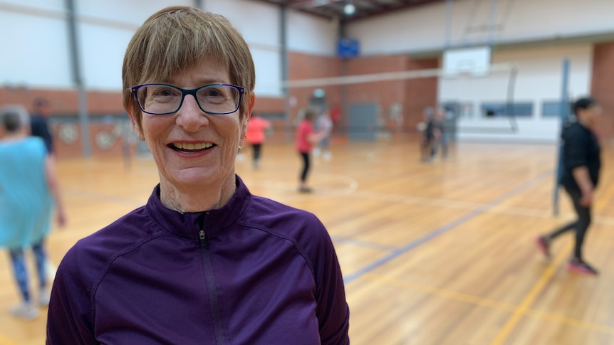 An elderly woman in a purple top