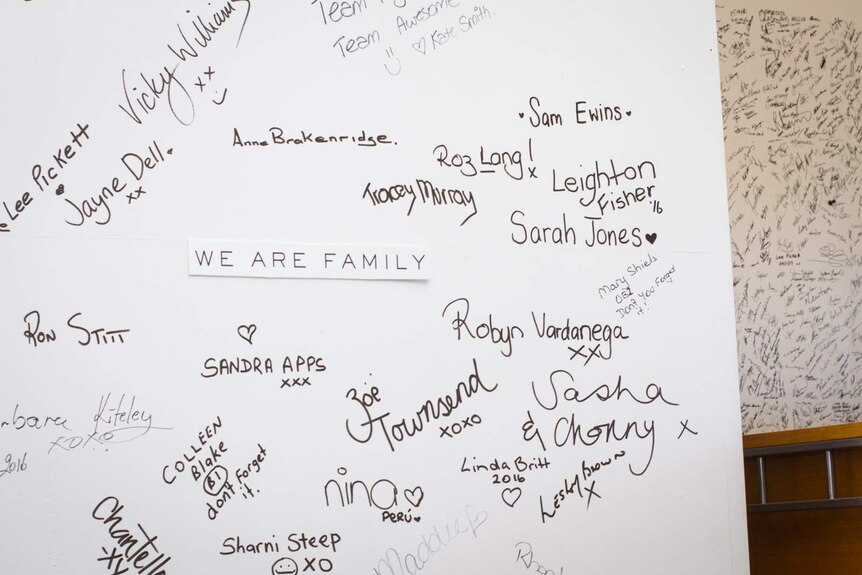A whiteboard with people's names and signatures written on it and the words 'We are family'