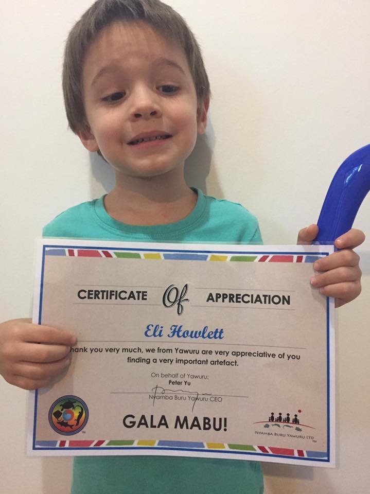 Eli Howlett holding a certificate of appreciation from the Yawuru Aboriginal corporation.