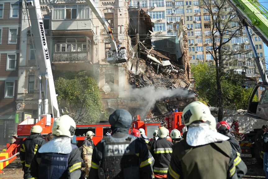 Firefighters sift through the rubble of a destroyed apartment building in Kyiv.