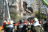 Firefighters sift through the rubble of a destroyed apartment building in Kyiv.