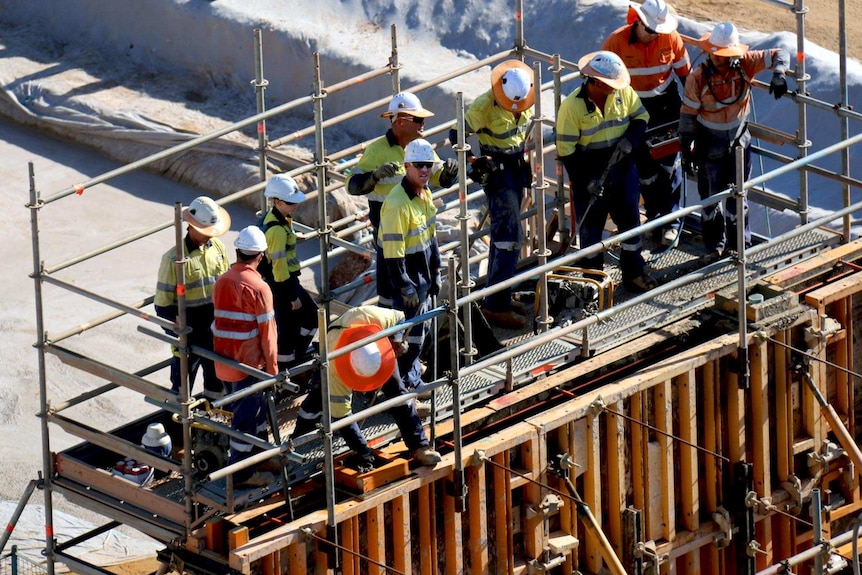 Group of construction workers on scaffolding.