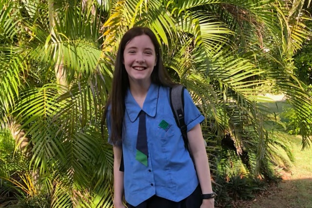 An image of isabella in her school uniform in front of trees