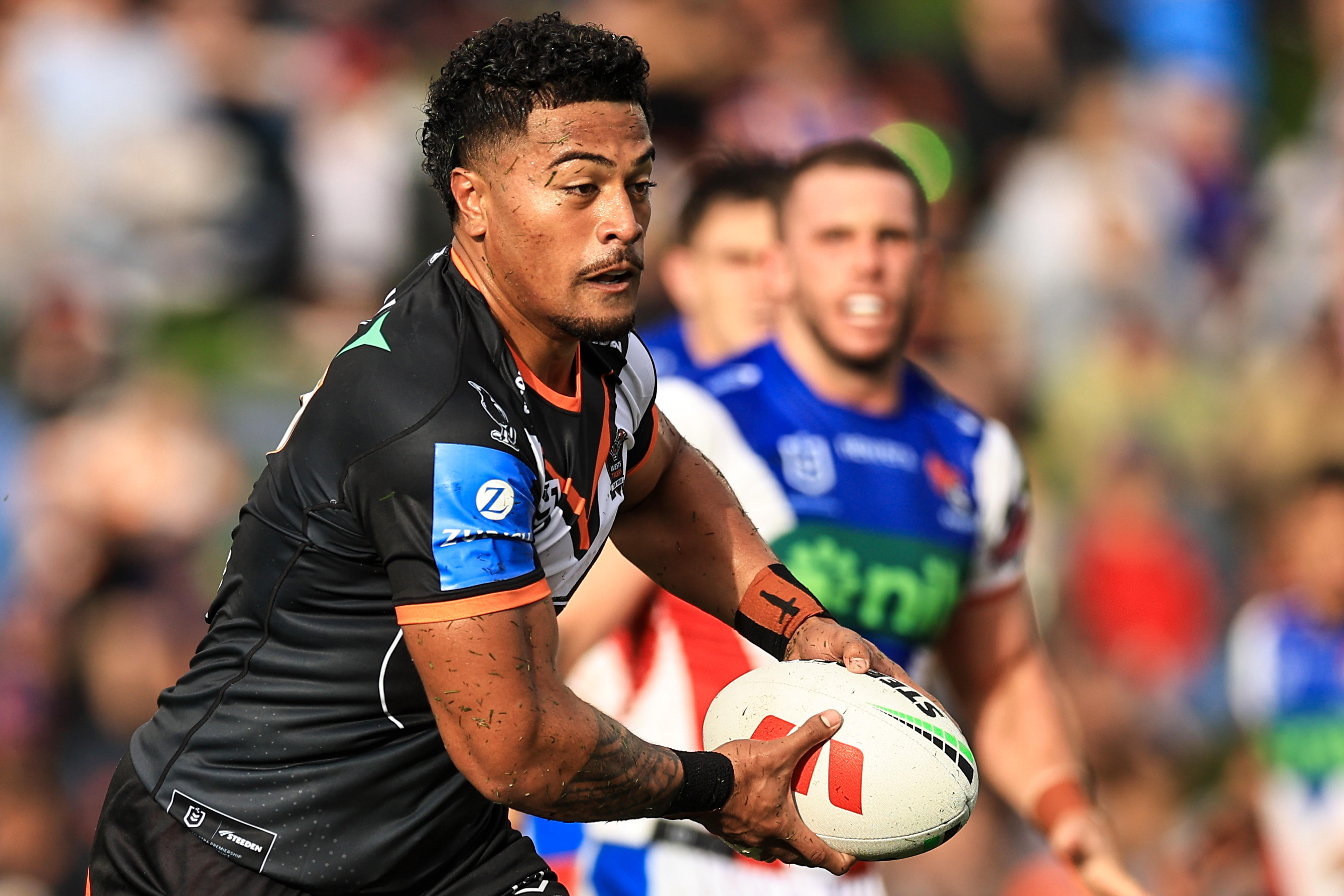 A man runs the ball during a rugby league match