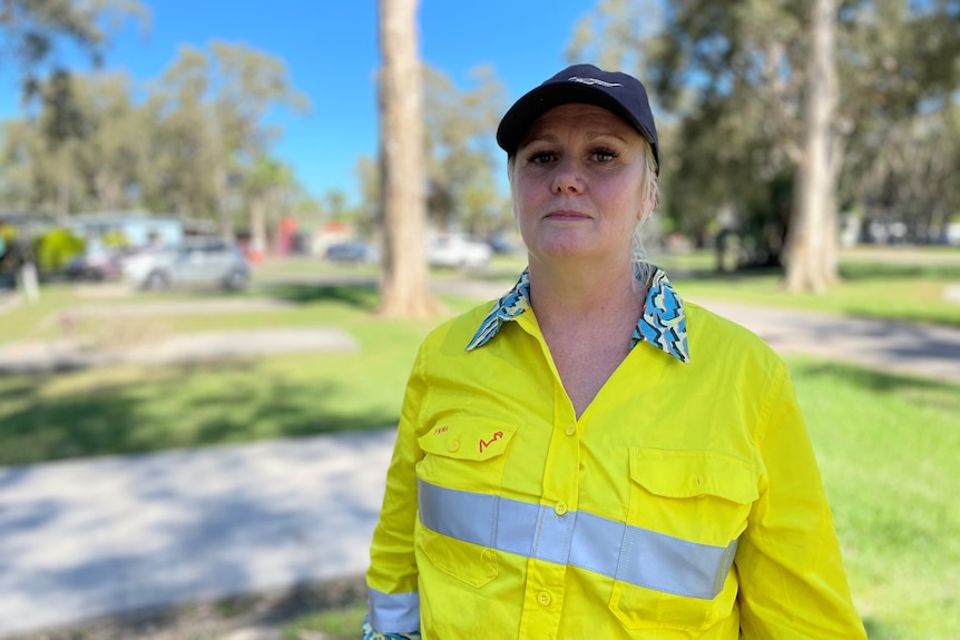 A woman with a high-visibility jacket and a black cap.