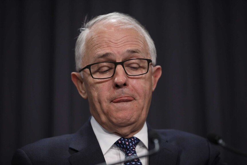 Malcolm Turnbull with his tongue between pursed lips in Parliament House in August 2018
