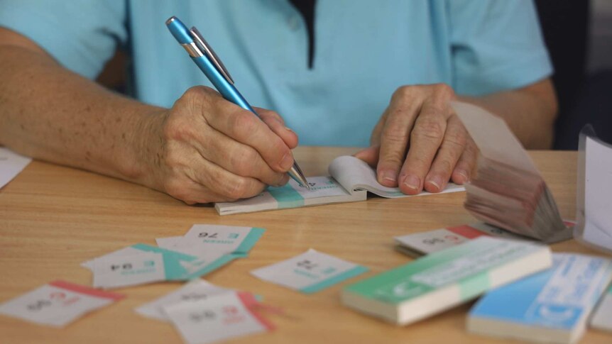 Close up of hands writing in raffle book